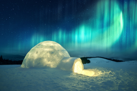 Aurora borealis. Northern lights in winter mountains. Wintry scene with glowing polar lights and...