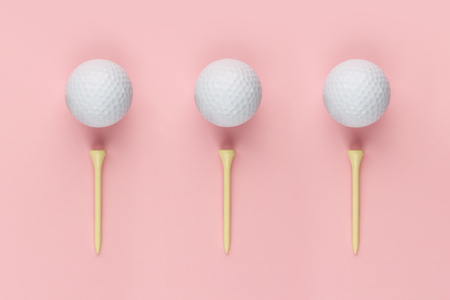 Three golf ball and wooden tee on pinkの写真素材