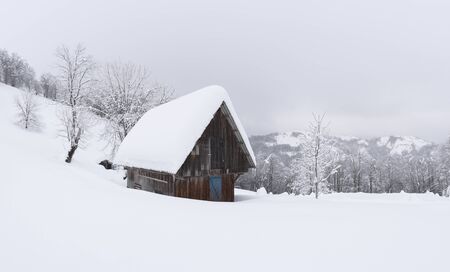Fantastic winter landscape with wooden house in snowy mountains. Christmas holiday conceptの写真素材