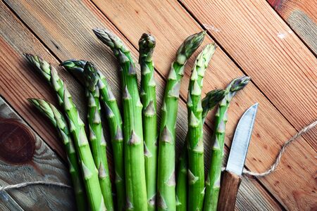 Green asparagus sprout on wooden board closeup. Top view flat lay. Food photographyの写真素材
