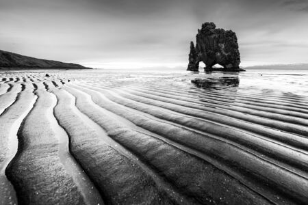 Drammatic landscape with famous Hvitserkur rock and dark wavy sand after the tide. Vatnsnes peninsula, Iceland, Europe. Black and white photoの写真素材