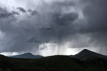 Amazing flowing rainy clouds in evening mountains. Beautiful nature of Carpathians. Landscape...