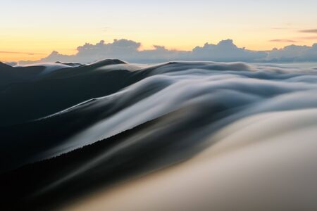 Amazing morning fog in mountains blurred from long exposure. Landscape photographyの写真素材