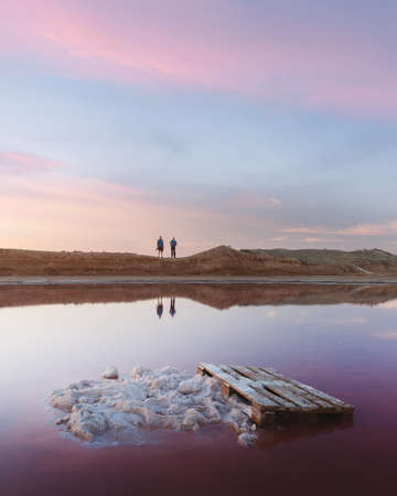 Salt crystals in pink water salt lake in Ukraine, Europe. Two photographers on background. Landscape photographyの写真素材