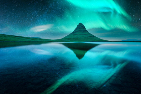 Aurora borealis Northern lights over Kirkjufell mountain volkano. Amazing night scene near famous Kirkjufell waterfall, Iceland. Landscape photographyの写真素材