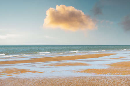 Tide waves on tropical beach sand and blue oceanの写真素材