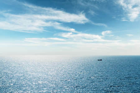 Lonely fishing ship trawler boat on oceanの写真素材