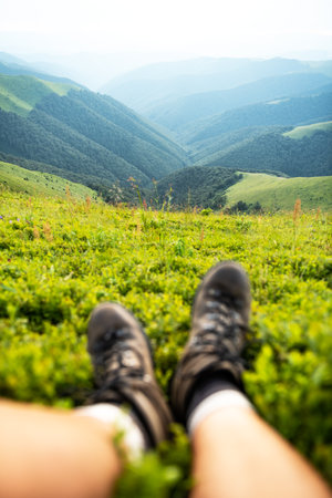 Boots of lonely tourist on lush blueberry bushsの写真素材