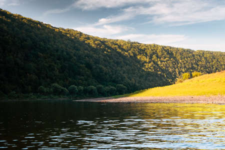 Summer river and lush autumn forest at sunrise timeの写真素材
