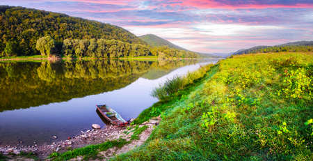Majestic foggy river and lush autumn forest at sunrise timeの写真素材