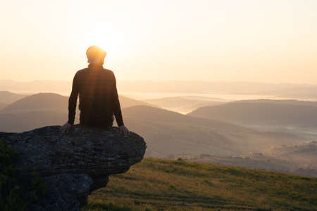 Alone tourist on the edge of the mountain hillの写真素材