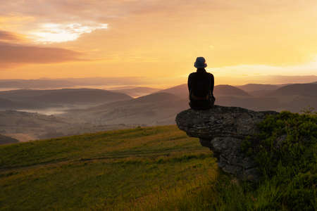 Alone tourist on the edge of the mountain hillの写真素材
