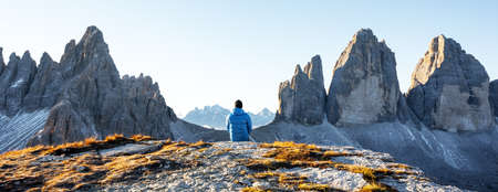 Tourist in blue jacket at Three Peaks of Lavaredo track on autumn seasonの写真素材