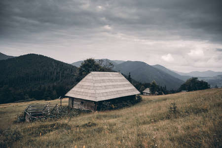Picturesque autumn meadow with old wooden houseの写真素材