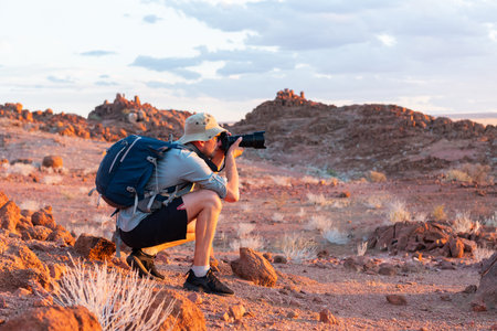 Photographer taking photo in rocks of Namib Desertの写真素材