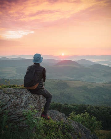 Alone tourist on the edge of the mountain hillの写真素材