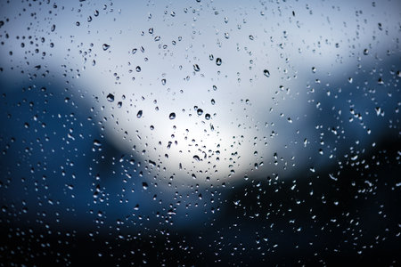 Raindrops on window glass on blue background