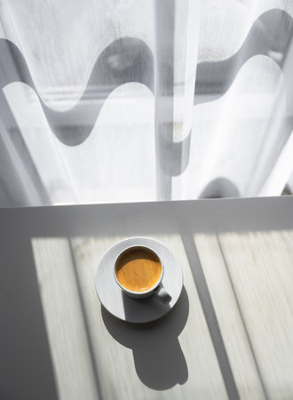 Espresso coffee cup on table near window