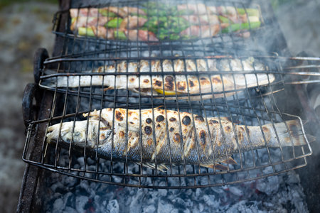 Grilling sea bass fish and asparagus on grillの写真素材