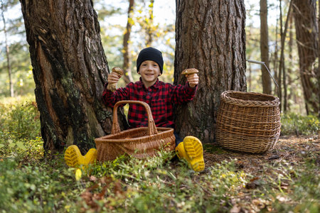 Small kid with mushrooms in autumn forestの写真素材