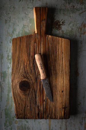Big kitchen knife lying on an old cutting boardの写真素材