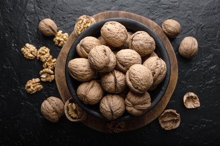 Walnut nuts, kernels and shell in wooden bowl