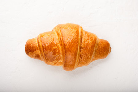 Close-up of freshly baked croissant on white background