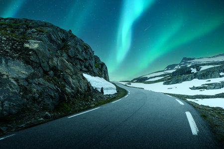 Northern lights above the famous mountain snowy road in Norwayの写真素材