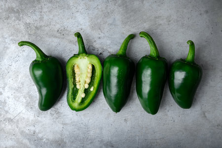 Green mexican jalapeno hot peppers on metal sheet