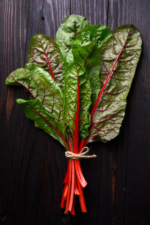 Bunch of organic red chard on a rustic wooden background