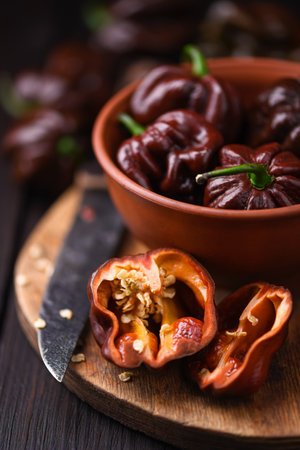 Ripened chocolate habanero peppers on wooden cutting boardの写真素材