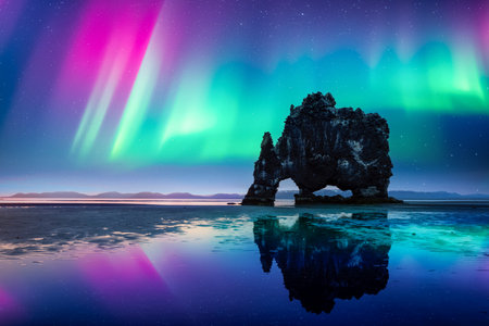 Purple and green Northern lights over Basalt stack Hvitserkurの写真素材