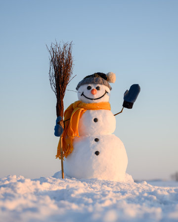 Funny snowman with broom and yellow scarfの写真素材