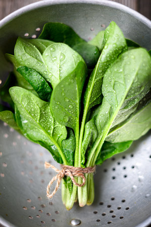 Close up of fresh green spinach leaves in a metal colander