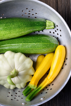 Old colander with fresh different kind zucchini and squash close upの写真素材