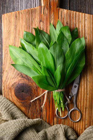 Bunch of vibrant green bears garlic on a wooden cutting boardの写真素材