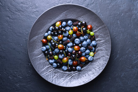 Fresh mixed berries including blueberries, blackcurrants, and mulberries