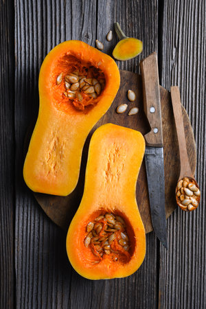 Two half of raw butternut squash with wooden spoonの写真素材