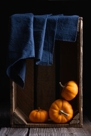 Three orange pumpkins in wooden boxの写真素材