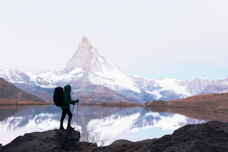 Silhouette of a tourist with a backpack on Matterhorn backgroundの写真素材