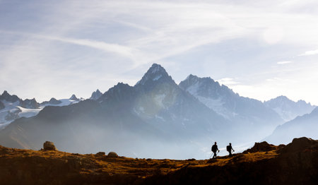 Two hikers walking above Lac de Cheserys in the French Alpsの写真素材