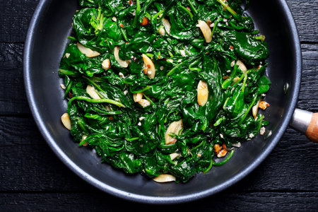 Flat lay of cooked spinach mixed with roasted garlicの写真素材