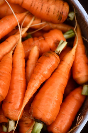 Carrots filling metal bowl photographed from above