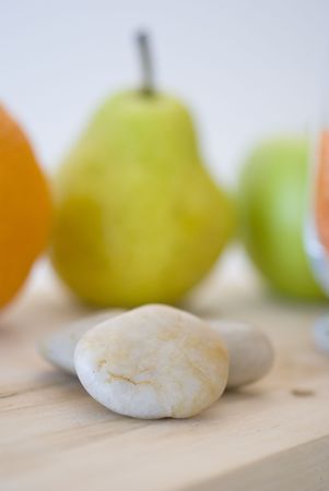 zen stones and orange, apple, pear fruits on backgroundの写真素材