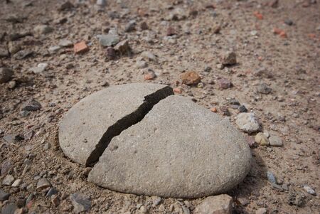 Dry field of cracked earth and cracked stoneの写真素材