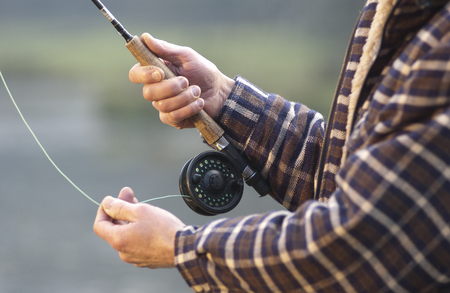 Close up on hands fishing rod and reel