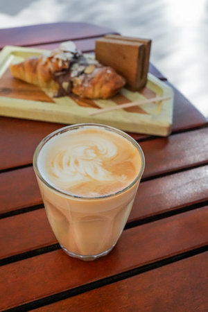 Coffee latte with croissant on a wooden tableの写真素材