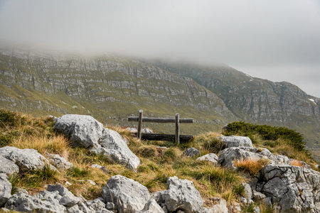Wooden bench on rocky hill under misty skyの写真素材