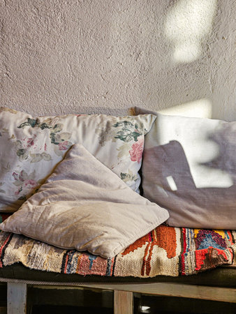 Close-up of cushions on bench near wallの写真素材