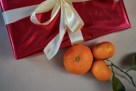 Close-Up Half Gift Box with Tangerines on Beige Backgroundの写真素材